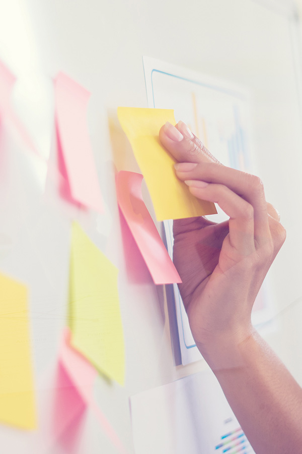 Post-Its werden während Workshop an Whiteboard geklebt